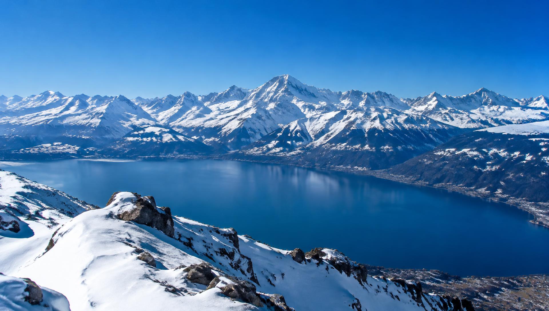 Snow-covered Swiss Alps under a deep blue sky